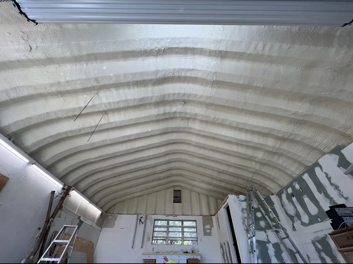 Spray polyurethane foam applied to the underside of a metal roof deck in Reynolds